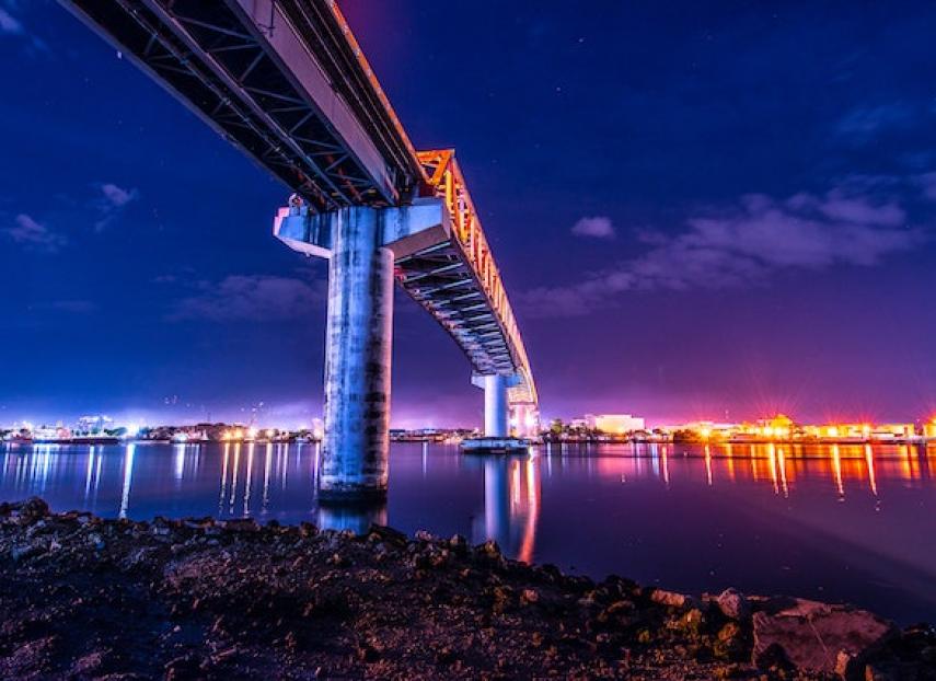 A view of a city at night from under a bridge