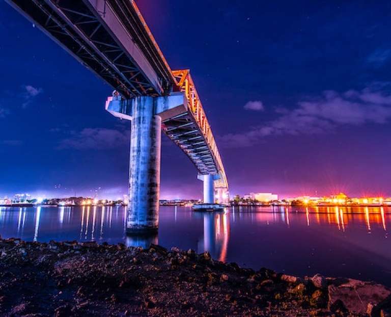 A view of a city at night from under a bridge